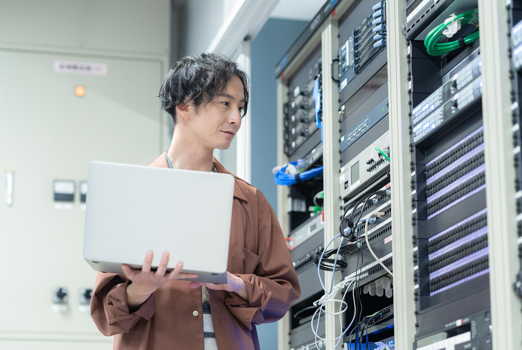 サーバー設備を確認しながらクラウドシステムを管理するエンジニア