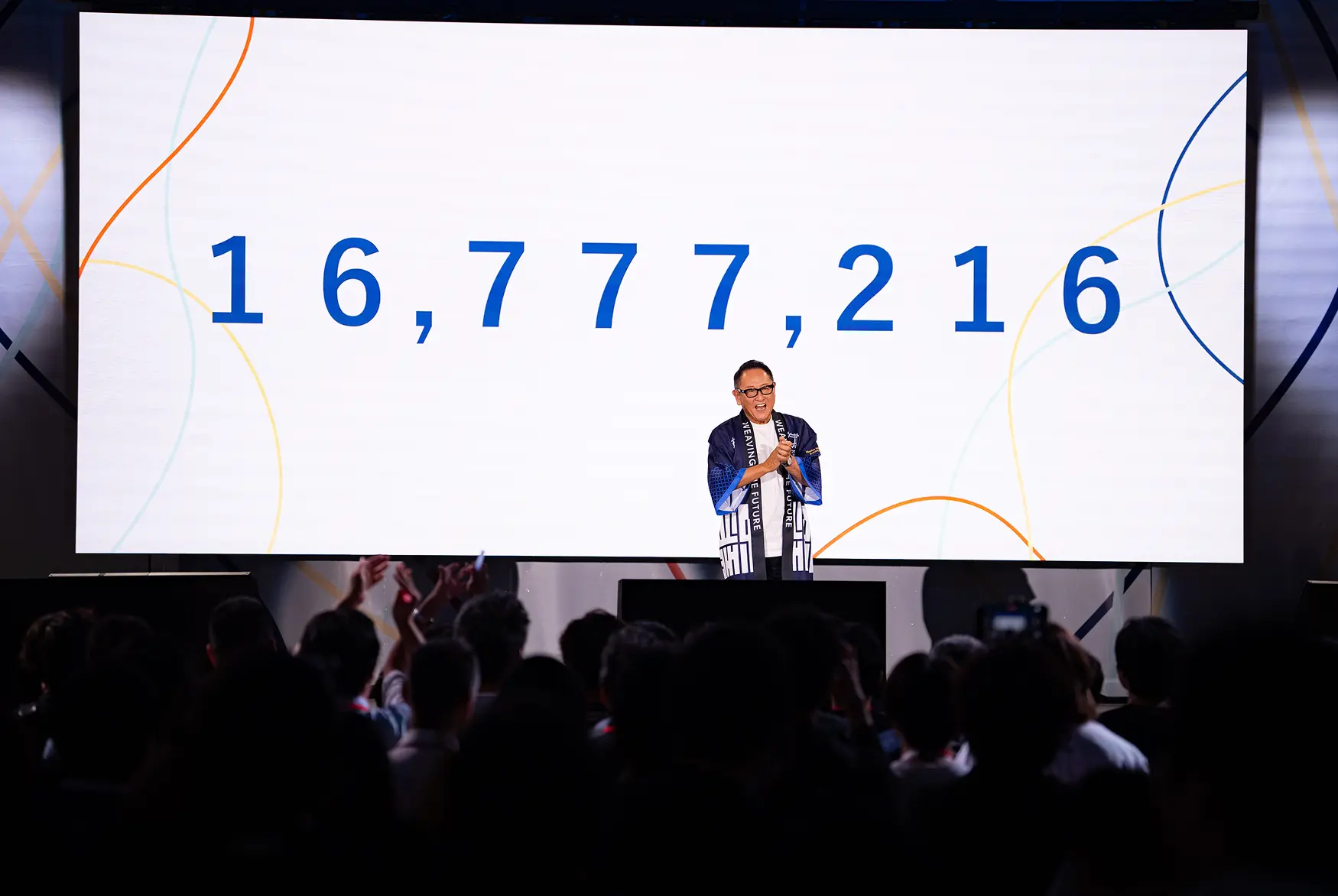 ウーブン・シティのローンチイベントでステージに登壇し発表する登壇者アキオ・トヨダ
