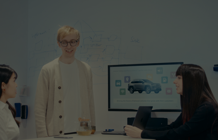 Employees discussing vehicle interface concepts in collaborative workspace