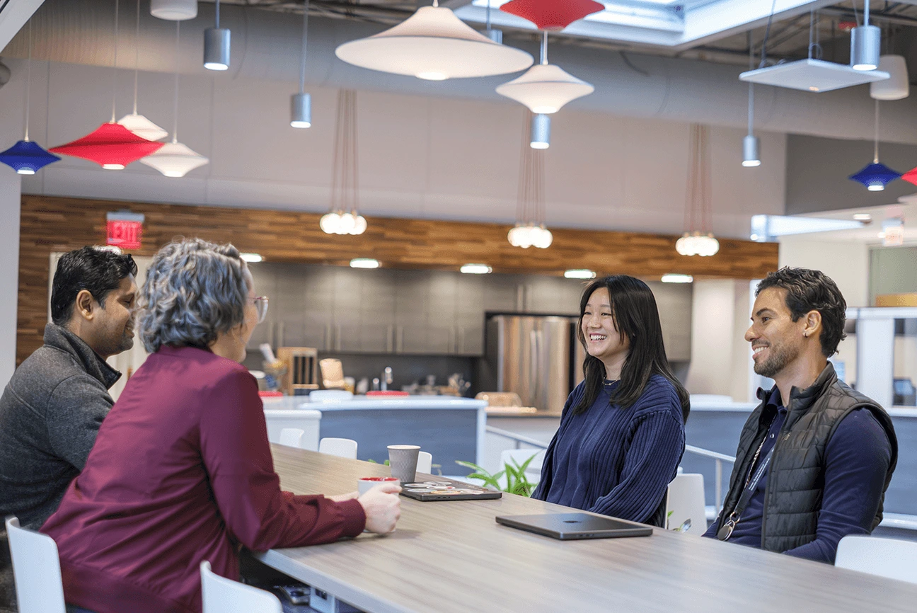 Employees collaborating in open office meeting space