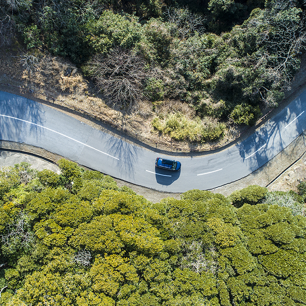 自然の中の曲がりくねった道路を走行する車両の俯瞰図